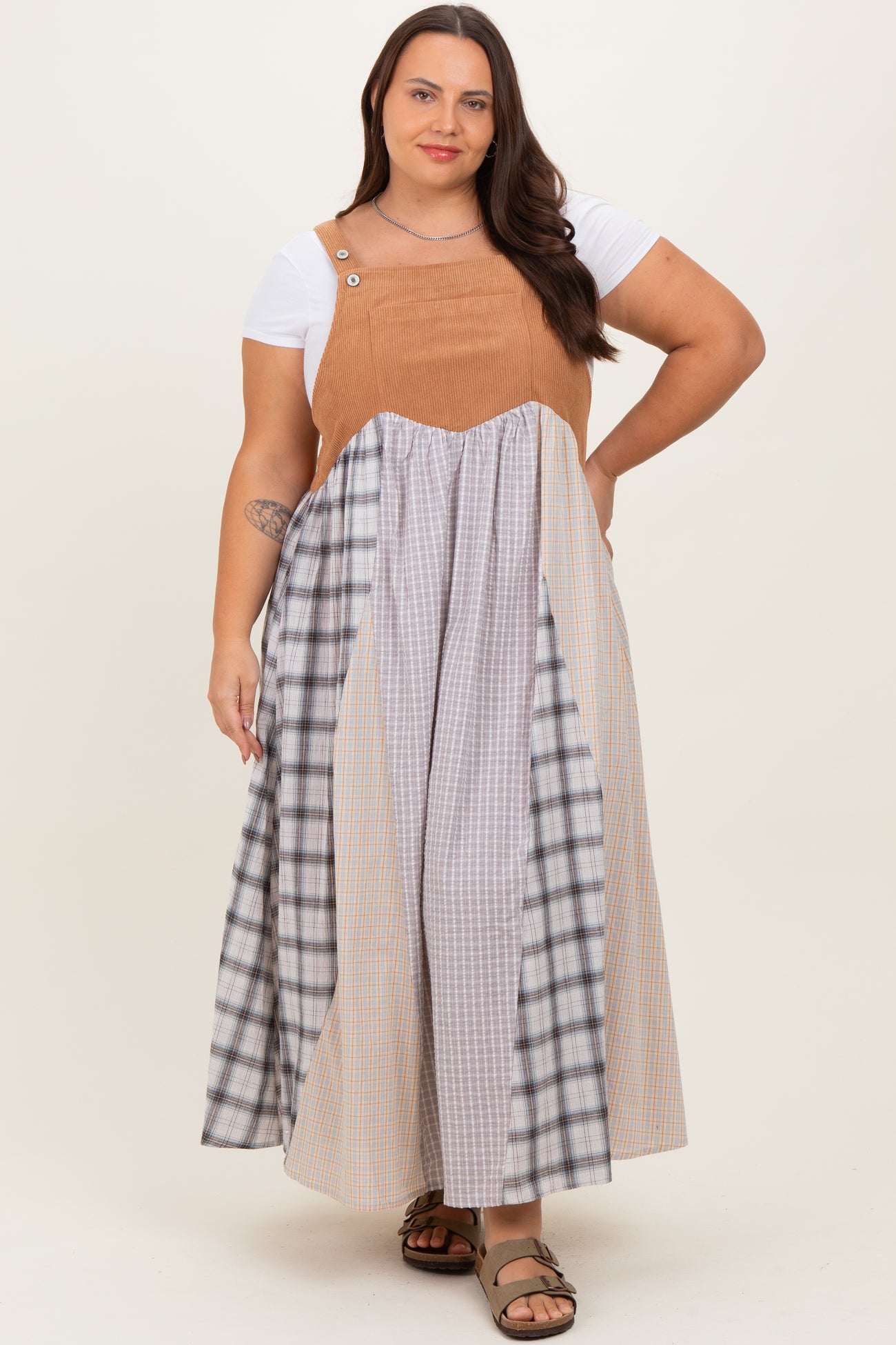 woman wearing a plus size color-blocked maxi dress with a brown top and plaid skirt sections