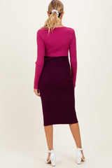 woman wearing a pink ribbed maternity top and a dark purple ribbed maternity skirt, showing a stylish layered look from the back