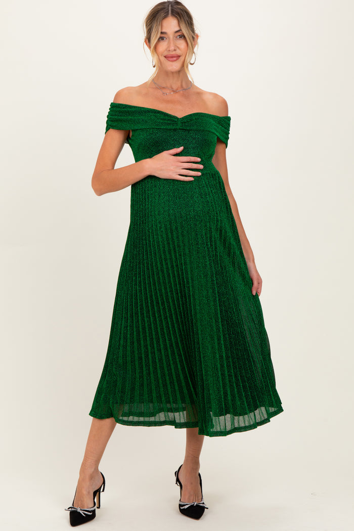 woman wearing a dark green pleated off-shoulder maternity dress with a visible baby bump