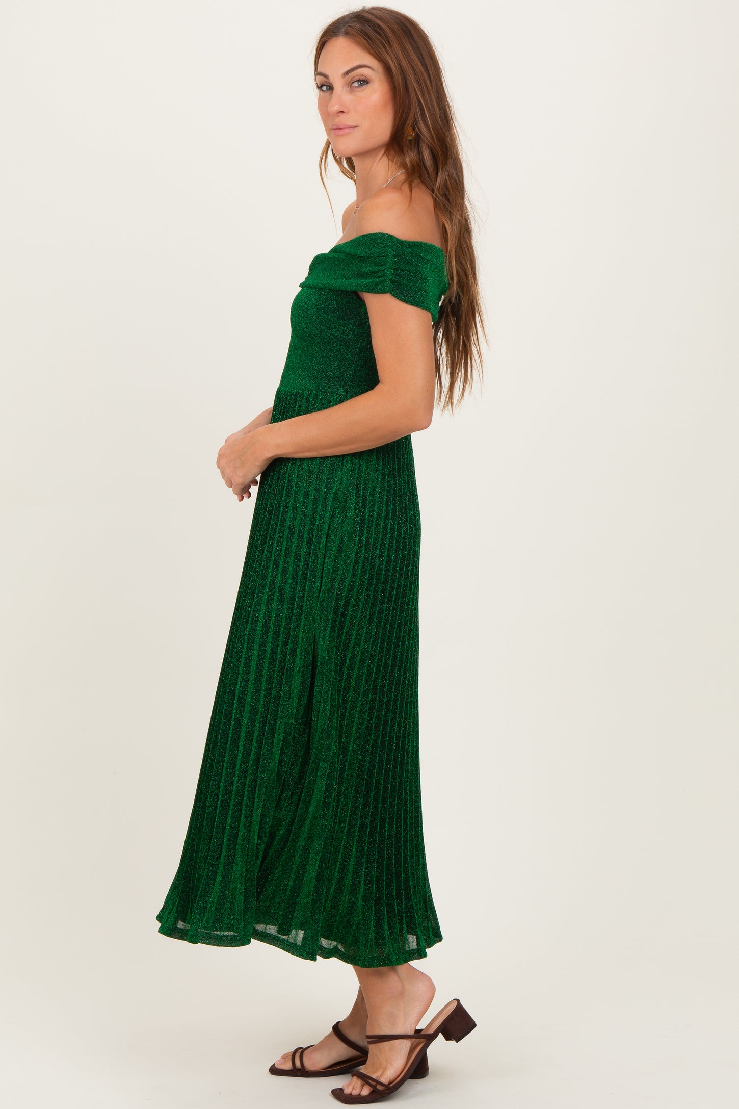 woman wearing a green off-the-shoulder ribbed maxi dress with a side slit and strappy sandals