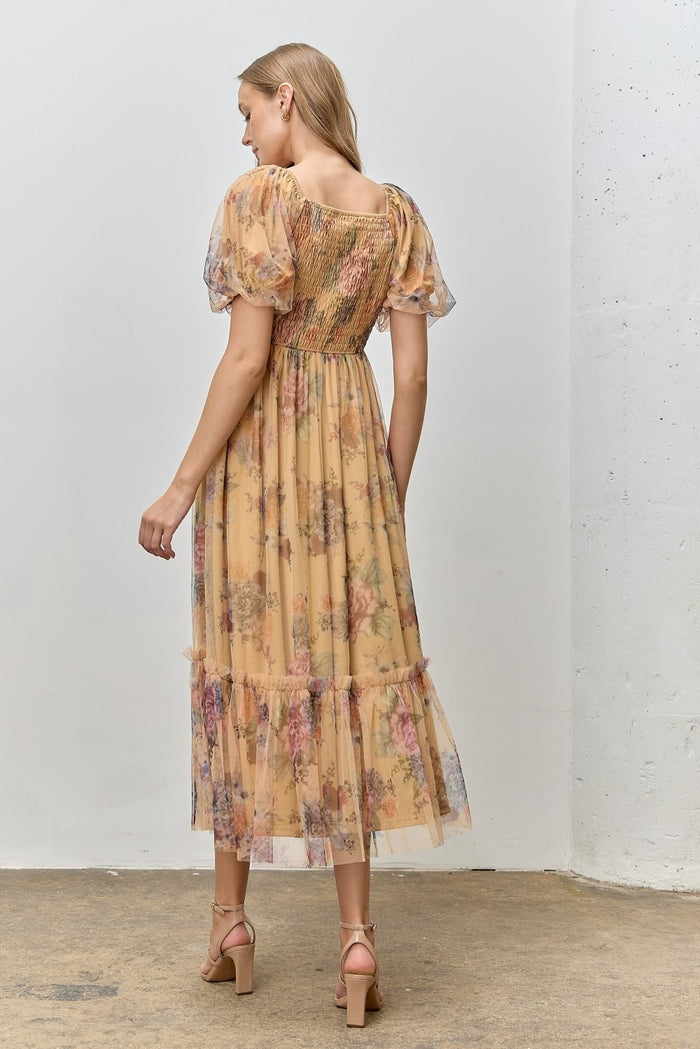woman wearing a floral print maxi dress with puff sleeves and ruffled hem, viewed from the back