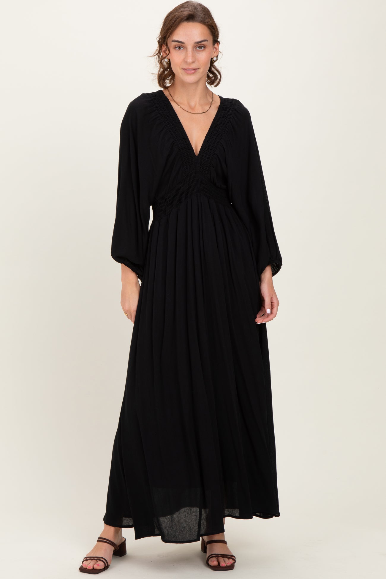 woman wearing a black maxi dress with a smocked bodice and long sleeves