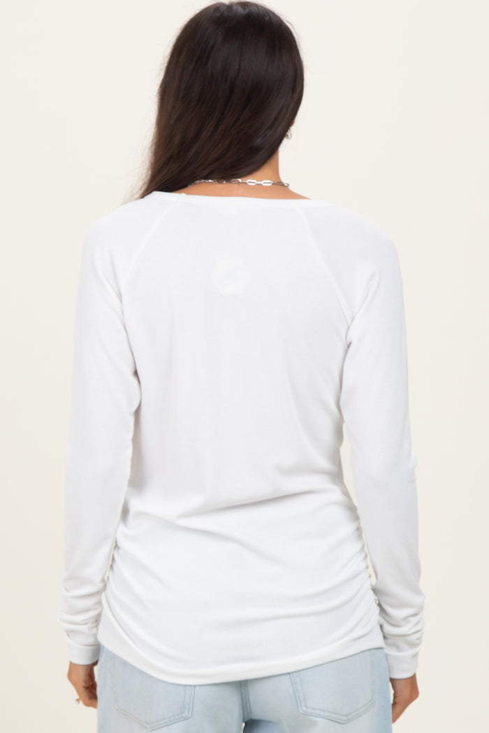 woman wearing a white long sleeve shirt with a curved hem and relaxed fit, viewed from the back