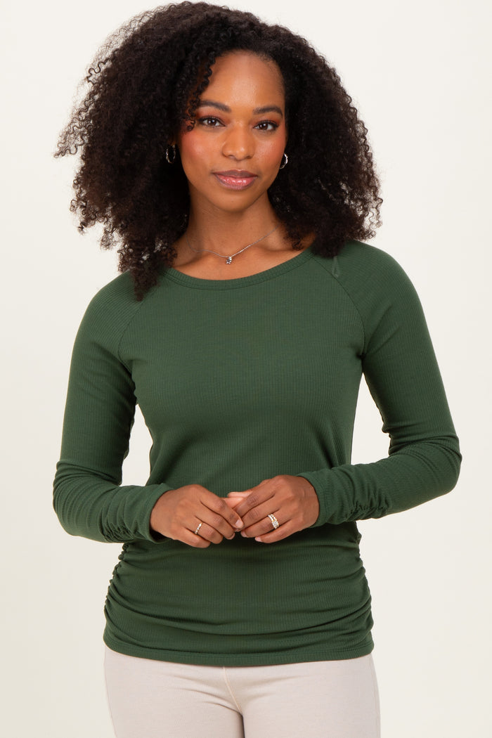 woman wearing a dark green long sleeve ribbed top with a relaxed fit and gathered side detail