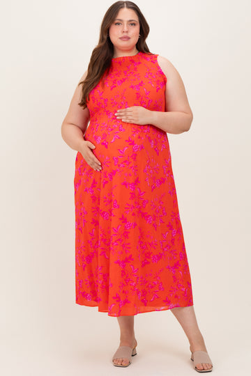 woman wearing a bright coral floral maternity dress with a high neckline and a baby bump visible