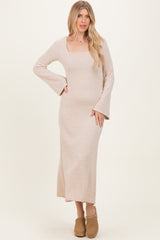 woman wearing a long beige ribbed maxi dress with a square neckline and bell sleeves, posing with one hand on her hip