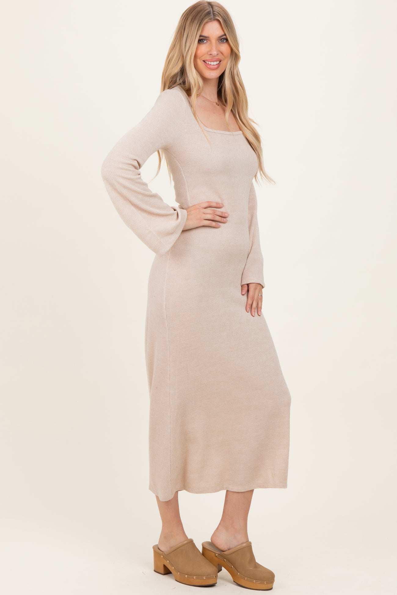 woman wearing a beige ribbed long sleeve maxi dress and tan clogs