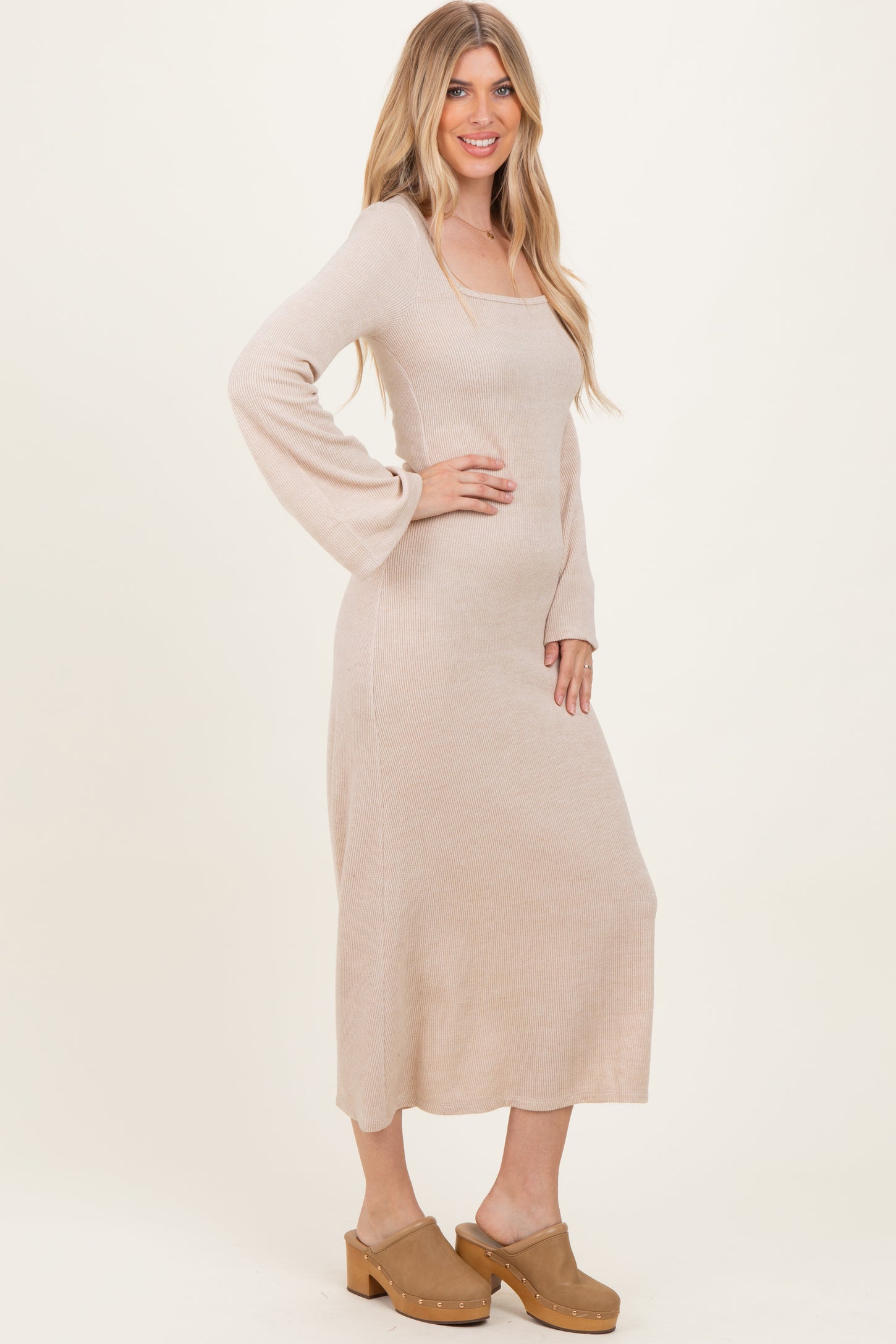 woman wearing a beige ribbed long sleeve maxi dress and tan clogs