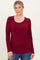 woman wearing a burgundy long sleeve henley top with button details and a scooped neckline