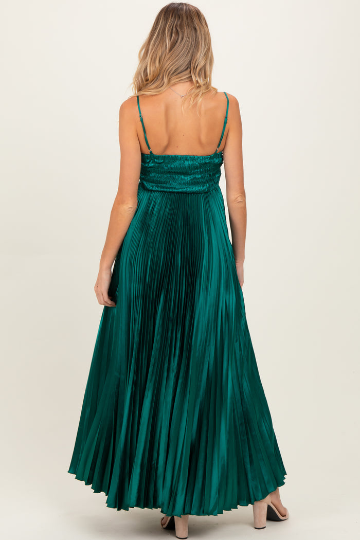woman wearing a green pleated maternity maxi dress with a smocked back and adjustable spaghetti straps