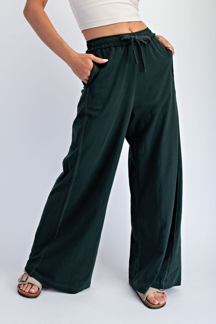 woman wearing green wide-leg pants with an elastic waistband and front pockets, styled with a cropped top