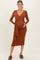 woman wearing a rust brown long sleeve maternity wrap dress and holding her baby bump