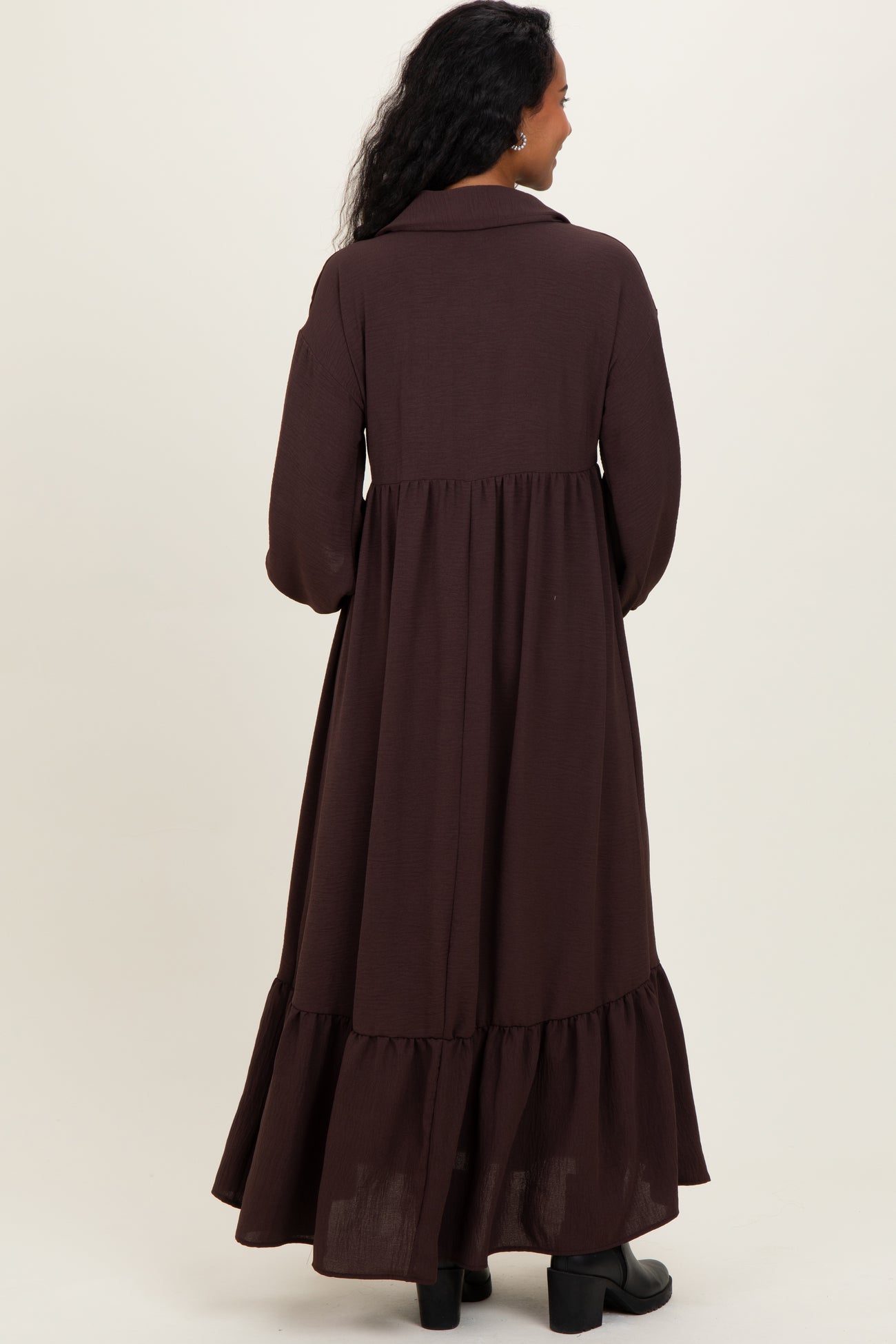 woman wearing a brown long sleeve maternity maxi dress with a tiered hem and a collared neck from the back