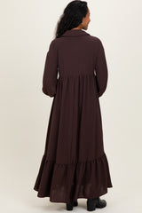 woman wearing a brown long sleeve maternity maxi dress with a tiered hem and a collared neck from the back