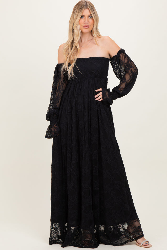 woman wearing a black off-shoulder lace maxi dress with long sleeves and a flowy skirt