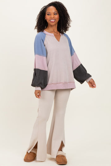 woman wearing a multicolor long sleeve top with balloon sleeves and beige flared pants