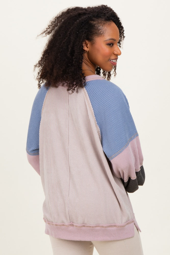 woman wearing a multicolored oversized striped sweater with a relaxed fit and raglan sleeves