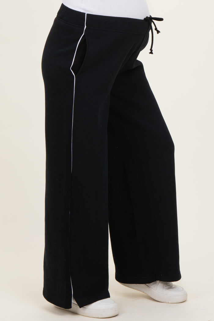 woman wearing black maternity sweatpants with white side stripes and drawstring waist