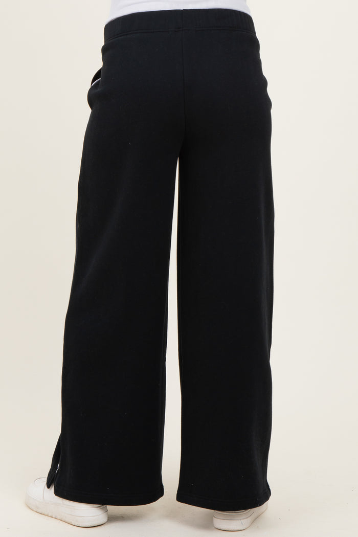 woman wearing black wide-leg maternity pants with a relaxed fit, showing the back view