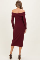 woman wearing a burgundy off-the-shoulder ribbed maternity dress with long sleeves and a fitted silhouette