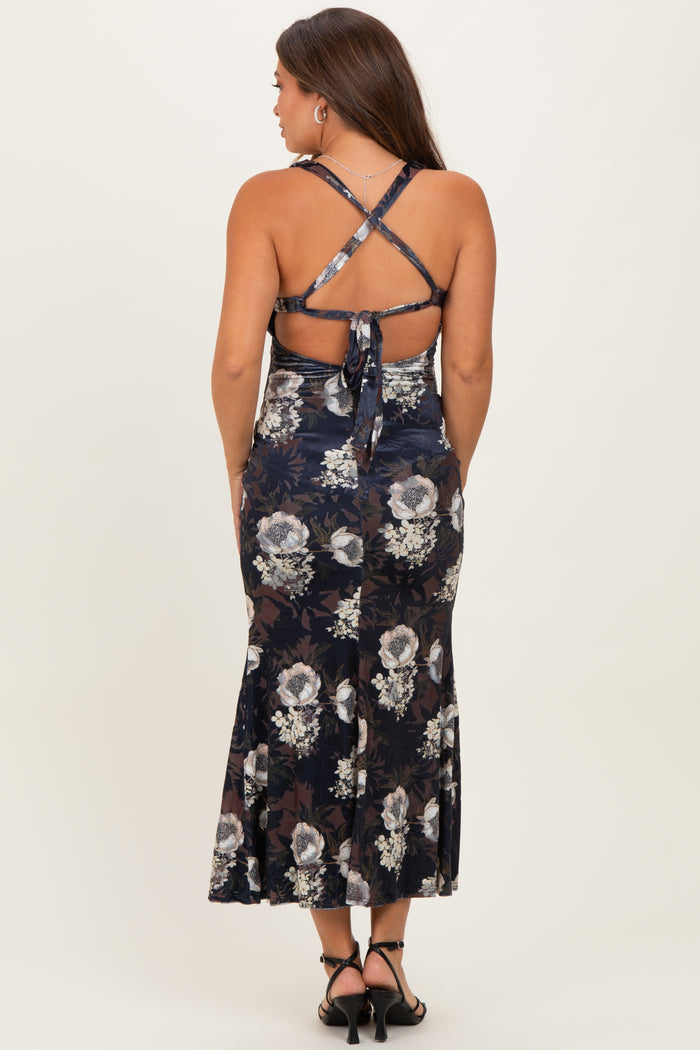 woman wearing a navy floral print maternity dress with a flared skirt and crisscross back straps