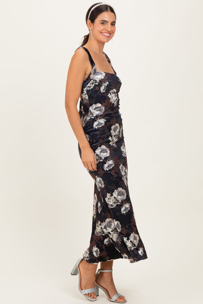 woman wearing a navy floral print maxi dress with spaghetti straps and a fitted silhouette