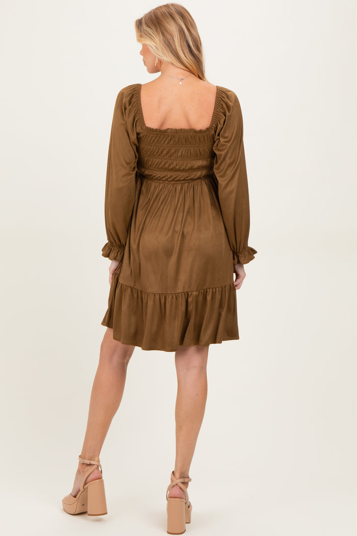 woman wearing a brown maternity dress with a smocked bodice and ruffled hem, showing her back