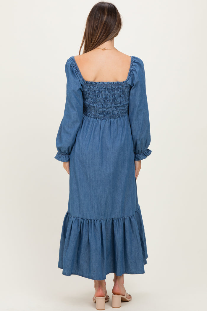 woman wearing a denim smocked maternity dress with long sleeves and a ruffled hem