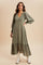 woman wearing an olive green long sleeve midi dress with a tiered skirt and button details, styled with white boots