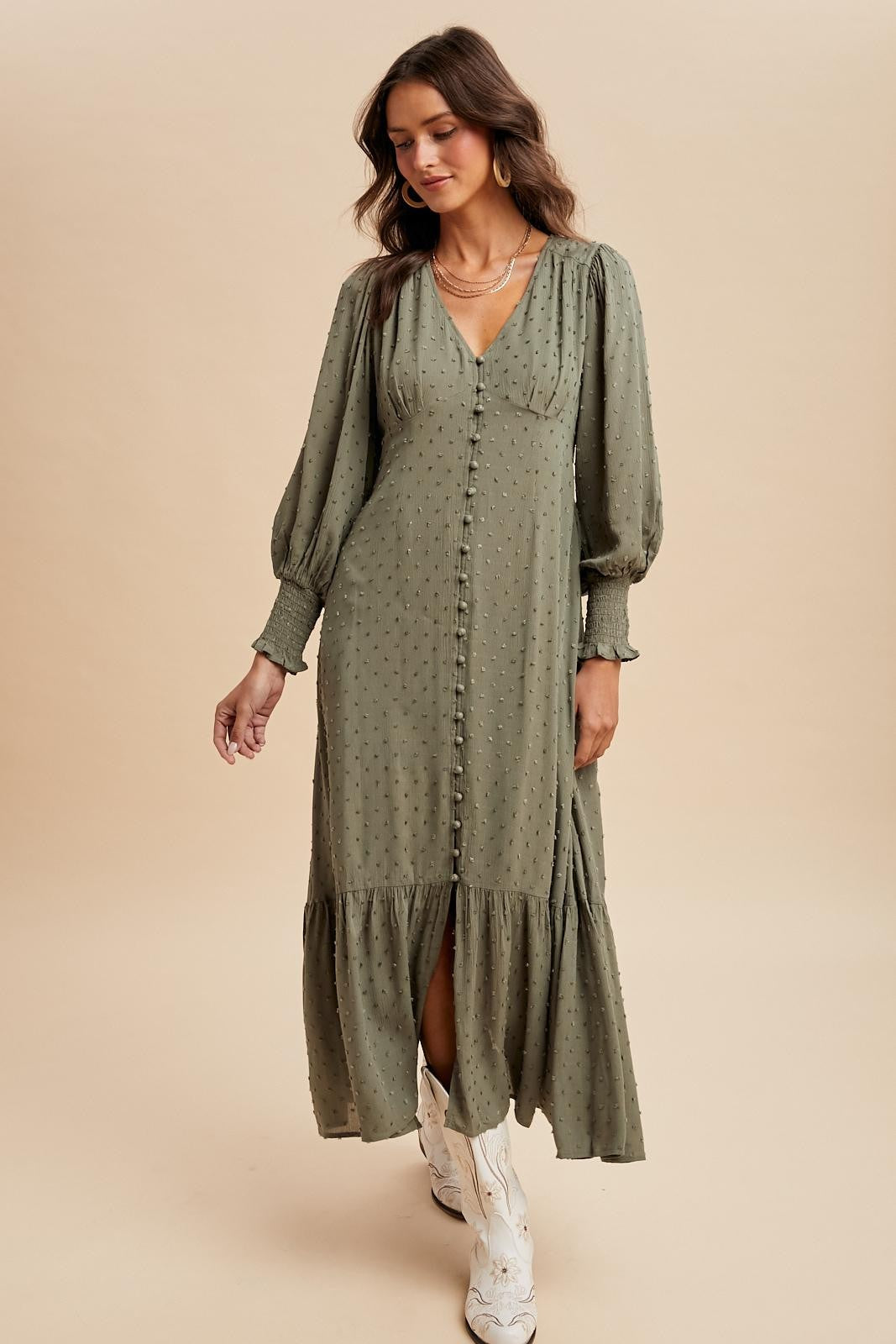 woman wearing a green long sleeve button-down dress with a tiered skirt and puffed sleeves