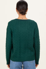 woman wearing a dark green cable knit sweater with a relaxed fit and crew neckline, seen from the back