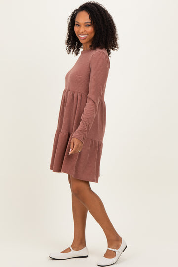 woman wearing a rust ribbed long sleeve dress with tiered layers and white flats