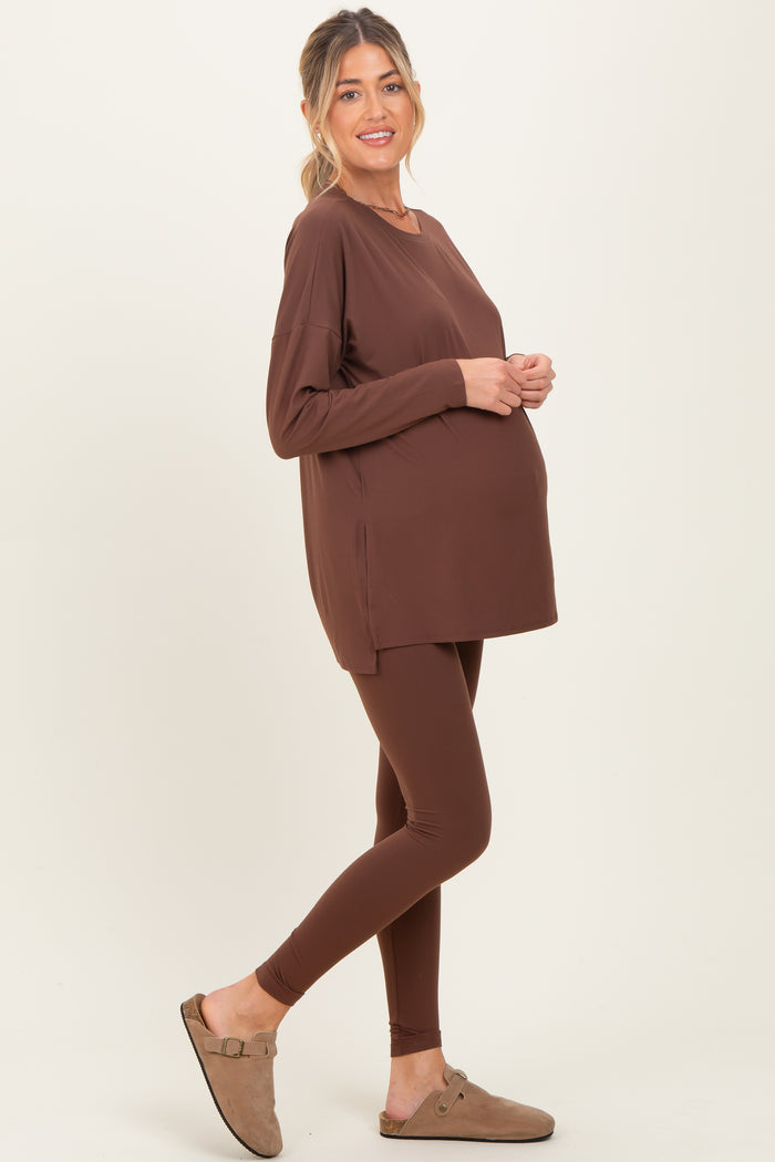 woman wearing a brown maternity long sleeve top and brown leggings, showcasing a baby bump