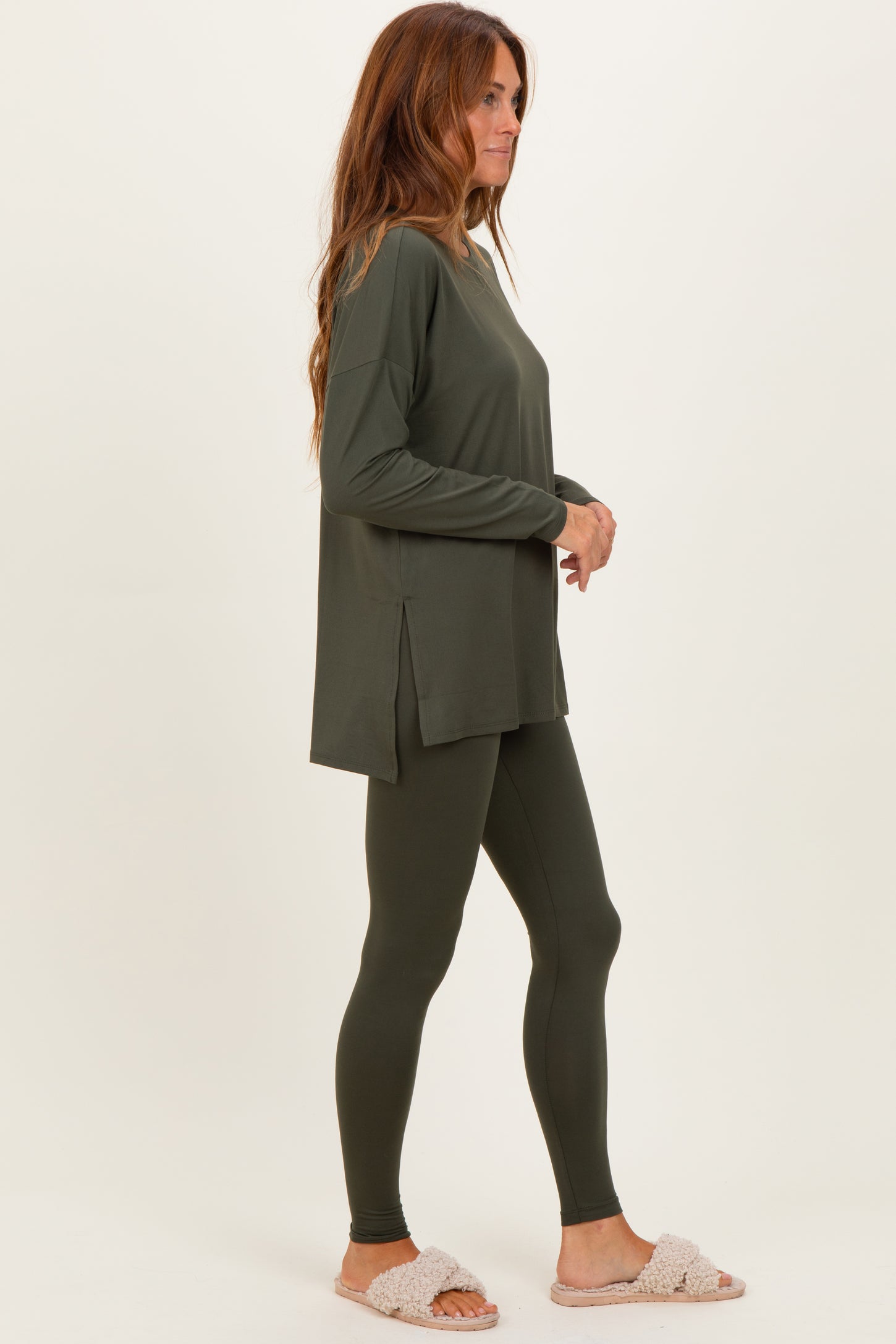 woman wearing an olive green long sleeve top and matching leggings, styled with cozy slippers