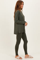 woman wearing an olive green long sleeve top and matching leggings, styled with cozy slippers
