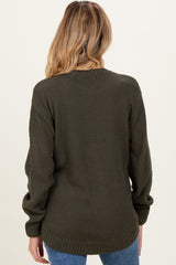 woman wearing a dark green maternity sweater with a textured pattern, showing the back view