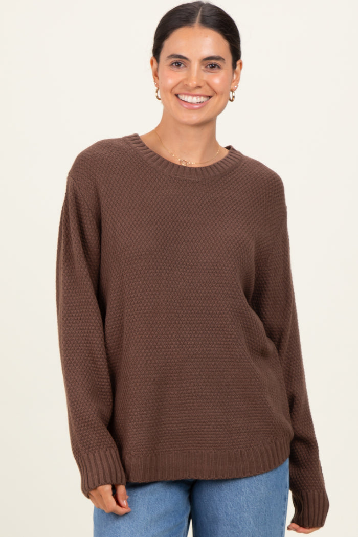 woman wearing a brown oversized textured sweater with a round neckline and long sleeves