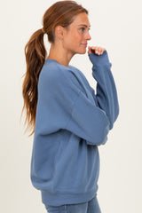 woman wearing a relaxed fit light blue sweatshirt with long sleeves and a crew neck