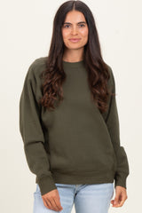 woman wearing a dark olive green sweatshirt with a relaxed fit and long sleeves