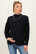 woman wearing a black maternity sweater with a relaxed fit and holding her baby bump