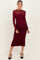 woman wearing a burgundy long sleeve maternity dress with ruched details and a visible baby bump