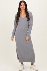 woman wearing a gray long sleeve knit maxi dress with a V-neck and side slits, styled with white sneakers