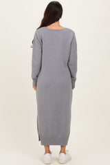 woman wearing a gray long sleeve knit sweater dress with a side slit and white sneakers, viewed from the back