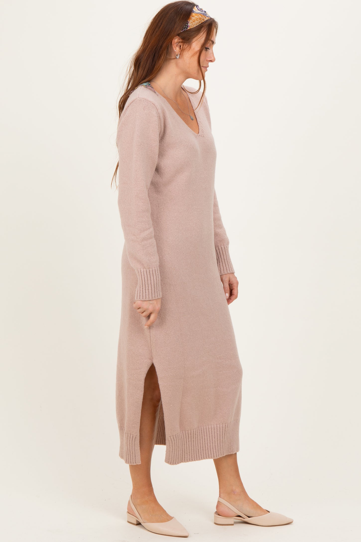 woman wearing a light pink long sleeve v-neck maxi dress with side slits and ribbed details