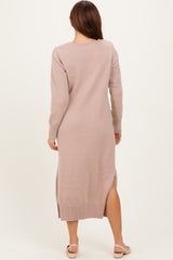 woman wearing a blush pink long sleeve knitted maxi dress with side slits and ribbed details