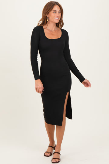 woman wearing a black ribbed long sleeve midi dress with a side slit and a scoop neckline, styled with strappy sandals