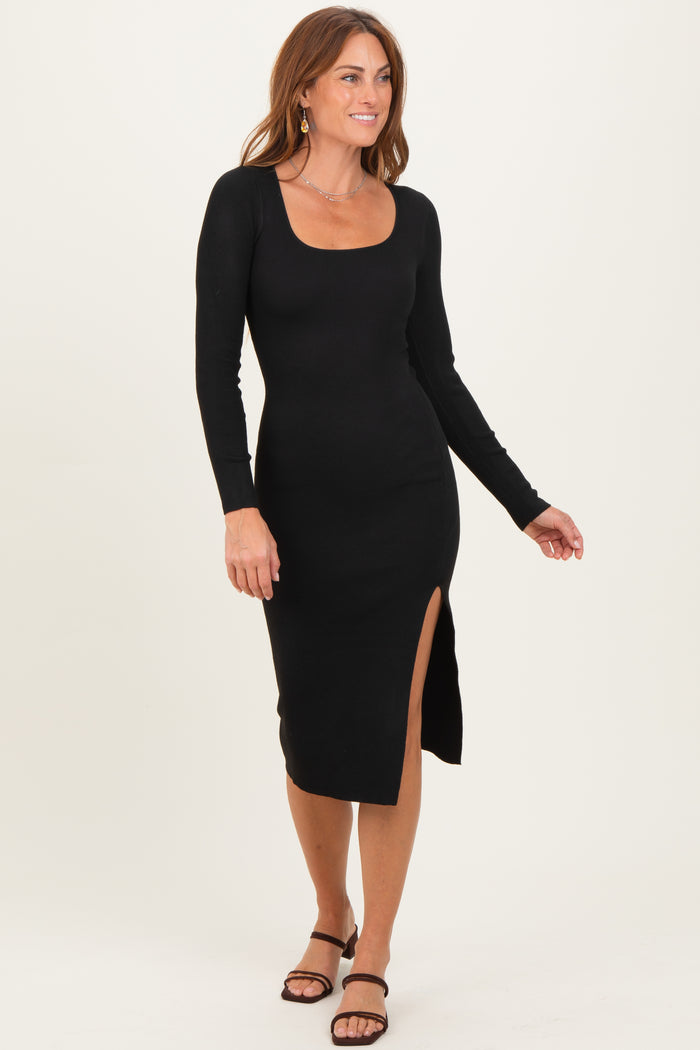 woman wearing a black ribbed long sleeve midi dress with a side slit and a scoop neckline, styled with strappy sandals