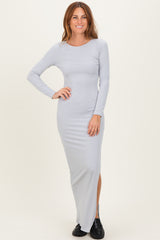 woman wearing a light gray ribbed long sleeve maxi dress with a side slit and black slip-on shoes