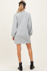 woman wearing a grey long sleeve maternity dress with a relaxed fit and balloon sleeves, showing the back view