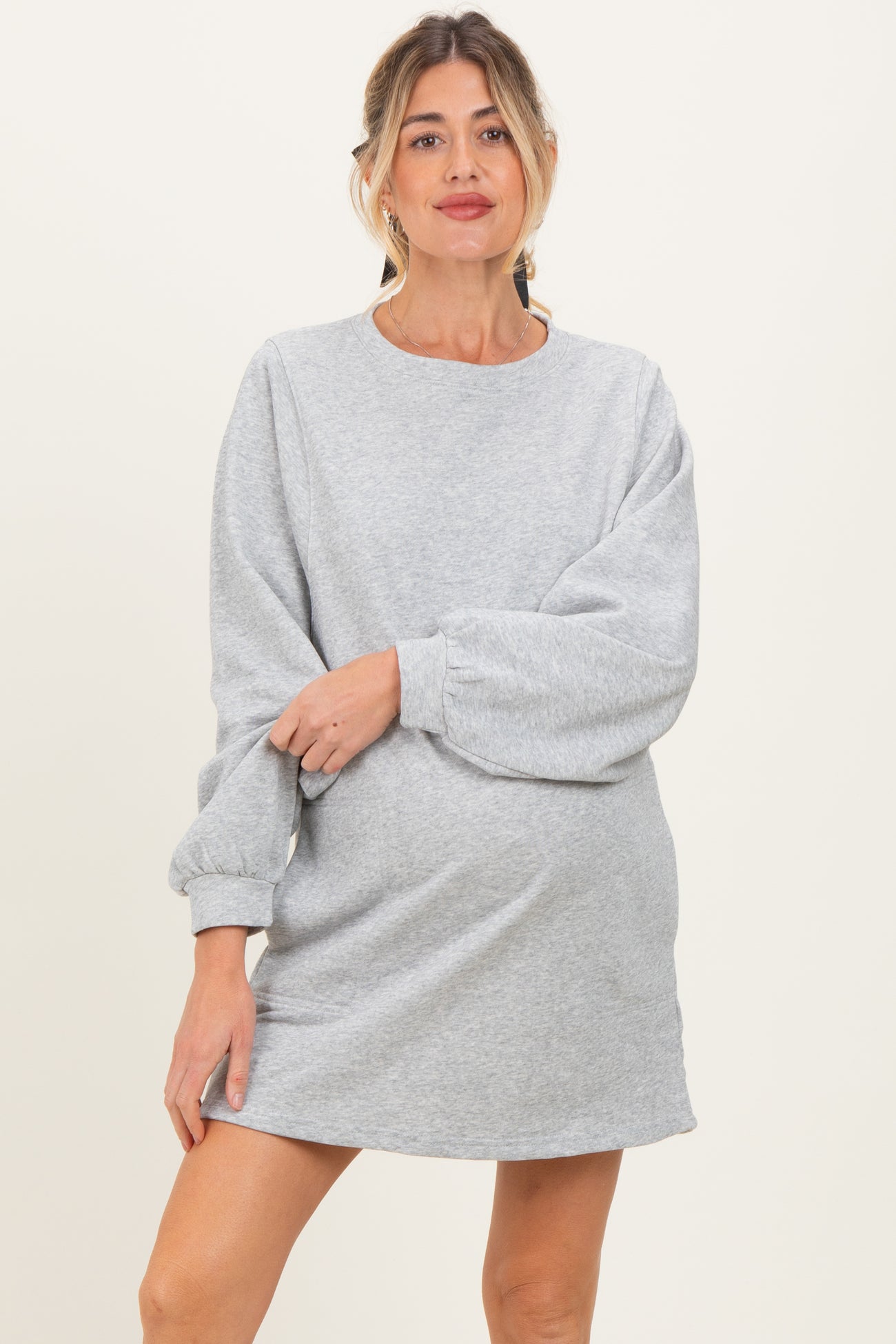 woman wearing a gray maternity sweatshirt dress with balloon sleeves and a visible baby bump